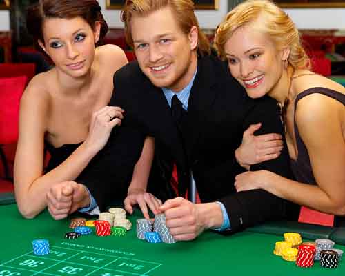 man gambling flanked by two women